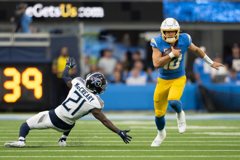 Los Angeles Chargers quarterback Justin Herbert (10) runs with the ball past Tennessee Titans cornerback Roger McCreary (21) during an NFL football game, Sunday, Nov. 10, 2024, in Inglewood, Calif. (AP Photo/Kyusung Gong)