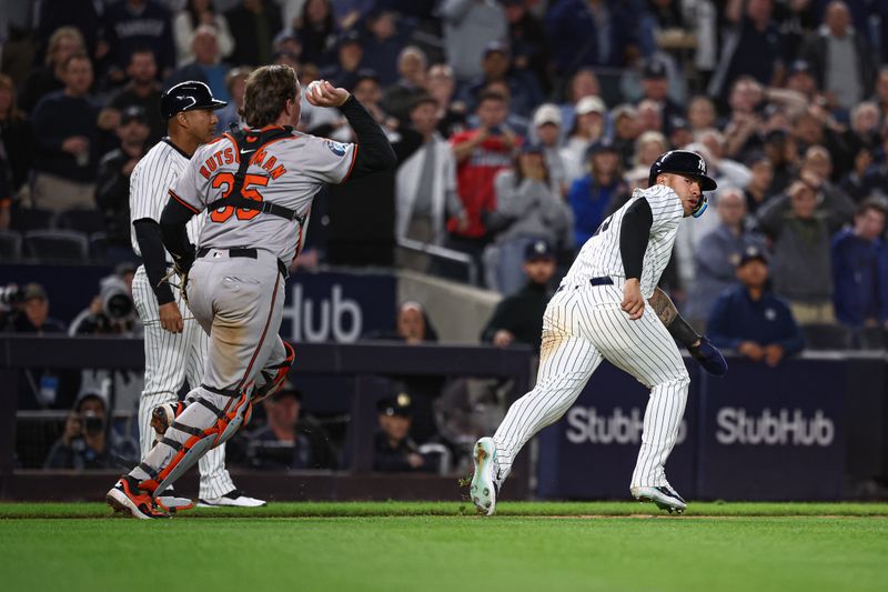 Sep 24, 2024; Bronx, New York, USA; New York Yankees second baseman Gleyber Torres (25) is caught in a run down as Baltimore Orioles catcher Adley Rutschman (35) throws the ball during the seventh inning at Yankee Stadium. Mandatory Credit: Vincent Carchietta-Imagn Images