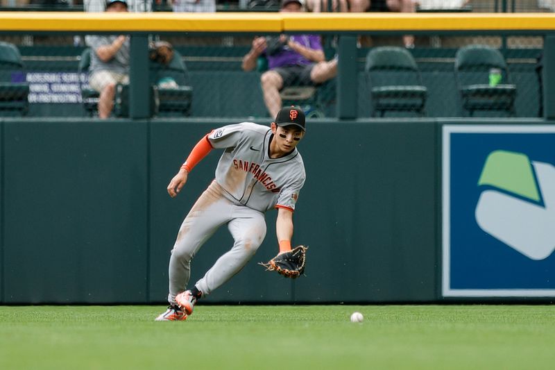 Jun 10, 2025; Denver, Colorado, USA; San Francisco Giants center fielder Jung Hoo Lee (51) fields the ball in the second inning against the Colorado Rockies at Coors Field. Mandatory Credit: Isaiah J. Downing-Imagn Images