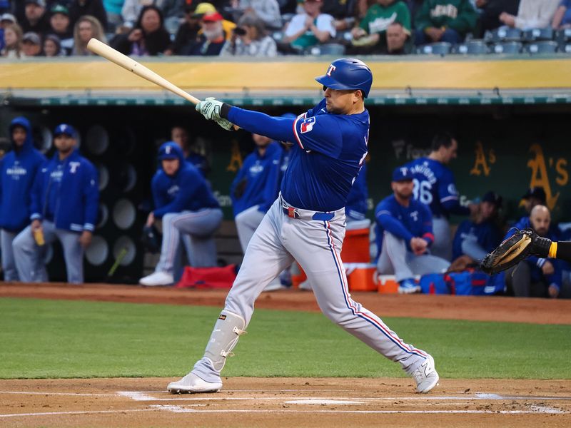 Sep 25, 2024; Oakland, California, USA; Texas Rangers first baseman Nathaniel Lowe (30) hits an RBI single against the Oakland Athletics during the first inning at Oakland-Alameda County Coliseum. Mandatory Credit: Kelley L Cox-Imagn Images