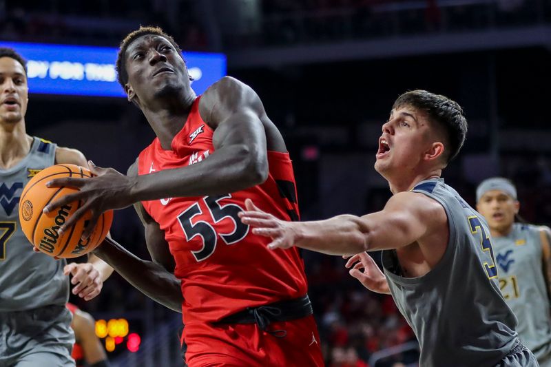 Mar 9, 2024; Cincinnati, Ohio, USA; Cincinnati Bearcats forward Aziz Bandaogo (55) drives to the basket against West Virginia Mountaineers guard Kerr Kriisa (3) in the first half at Fifth Third Arena. Mandatory Credit: Katie Stratman-USA TODAY Sports