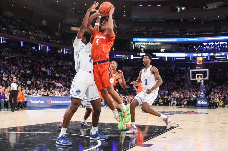 Dec 9, 2025; New York, New York, USA;  Clemson Tigers guard Efrem Johnson (4) drives past BYU Cougars forward Khadim Mboup (7) in the second half at Madison Square Garden. Mandatory Credit: Wendell Cruz-Imagn Images