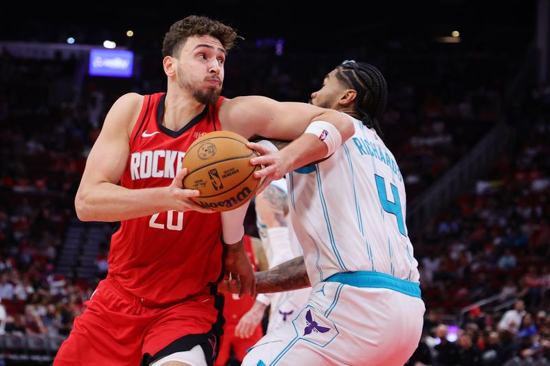 HOUSTON, TEXAS - OCTOBER 23: Alperen Sengun #28 of the Houston Rockets drives against Nick Richards #4 of the Charlotte Hornets during the second half at Toyota Center on October 23, 2024 in Houston, Texas.  NOTE TO USER: User expressly acknowledges and agrees that, by downloading and or using this photograph, User is consenting to the terms and conditions of the Getty Images License Agreement. (Photo by Alex Slitz/Getty Images)