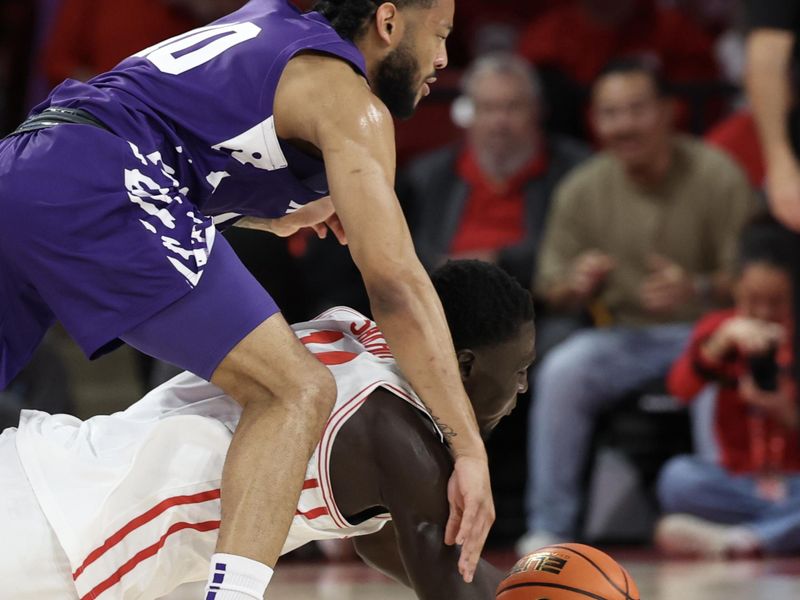 Feb 14, 2026; Houston, Texas, USA;  Kansas State guard David Castillo (10) and Houston Cougars forward Kalifa Sakho (14) reach for a loose ball in the first half at Fertitta Center. Mandatory Credit: Thomas Shea-Imagn Images