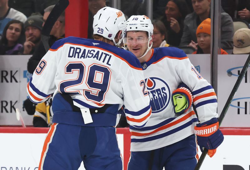 Dec 16, 2025; Pittsburgh, Pennsylvania, USA;  Edmonton Oilers left wing Zach Hyman (18) congratulates center Leon Draisaitl (29) on his 1000th career NHL point which was an assist against the Pittsburgh Penguins during the first period at PPG Paints Arena. Mandatory Credit: Charles LeClaire-Imagn Images