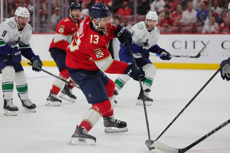 Oct 17, 2024; Sunrise, Florida, USA; Florida Panthers center Sam Reinhart (13) moves the puck against the Vancouver Canucks during the third period at Amerant Bank Arena. Mandatory Credit: Sam Navarro-Imagn Images