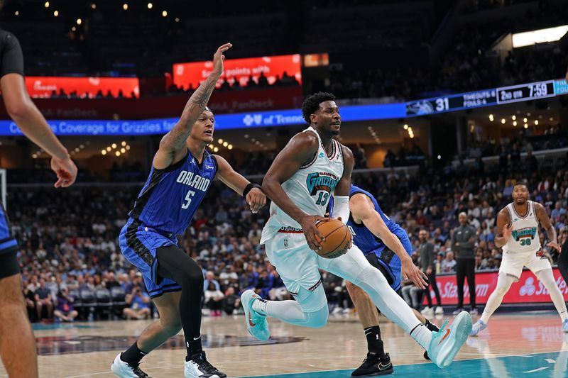 MEMPHIS, TENNESSEE - OCTOBER 26: Jaren Jackson Jr. #13 of the Memphis Grizzlies goes to the basket against Paolo Banchero #5 of the Orlando Magic during the first half at FedExForum on October 26, 2024 in Memphis, Tennessee. NOTE TO USER: User expressly acknowledges and agrees that, by downloading and or using this photograph, User is consenting to the terms and conditions of the Getty Images License Agreement. (Photo by Justin Ford/Getty Images)