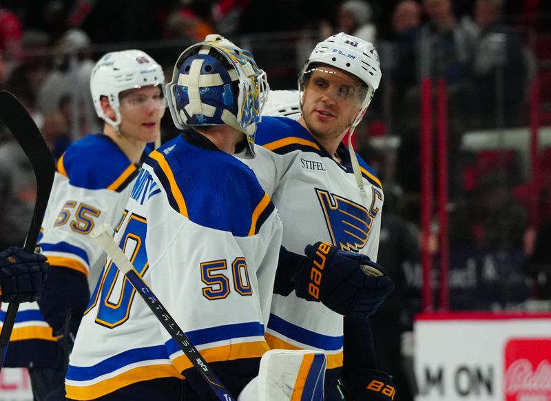 Jan 6, 2024; Raleigh, North Carolina, USA; St. Louis Blues goaltender Jordan Binnington (50) and center Brayden Schenn (10) celebrate their victory in the shoot out against the Carolina Hurricanes at PNC Arena. Mandatory Credit: James Guillory-USA TODAY Sports