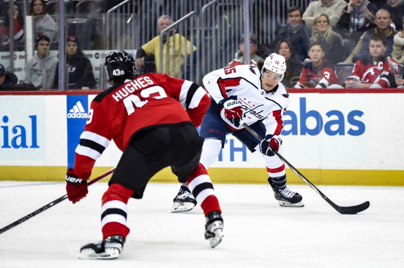 Nov 10, 2023; Newark, New Jersey, USA; Washington Capitals left wing Sonny Milano (15) looks to pass the puck as New Jersey Devils defenseman Luke Hughes (43) defends during the third period at Prudential Center. Mandatory Credit: John Jones-USA TODAY Sports