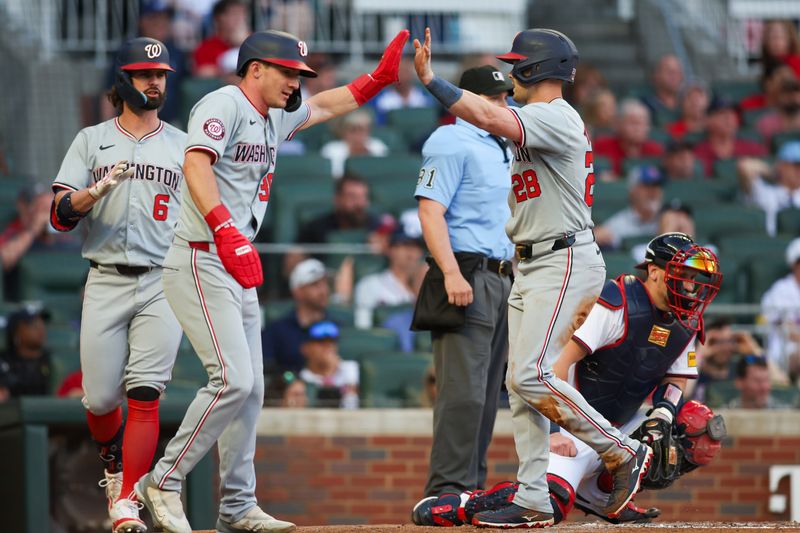 May 30, 2024; Atlanta, Georgia, USA; Washington Nationals center fielder Jacob Young (30) and right fielder Lane Thomas (28) celebrate after scoring against the Atlanta Braves in the third inning at Truist Park. Mandatory Credit: Brett Davis-USA TODAY Sports