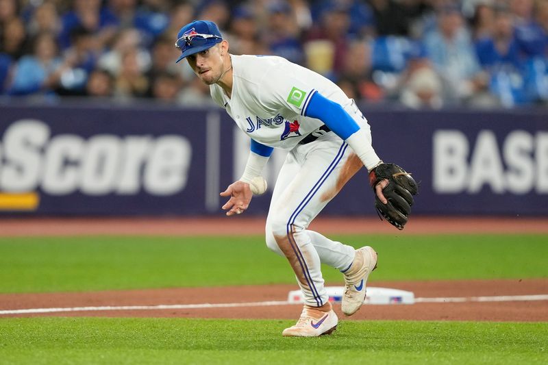 Sep 8, 2023; Toronto, Ontario, CAN; Toronto Blue Jays third baseman Cavan Biggio (8) mishandles a bunt from Kansas City Royals catcher Freddy Fermin (not pictured) during the fifth inning at Rogers Centre. Mandatory Credit: John E. Sokolowski-USA TODAY Sports