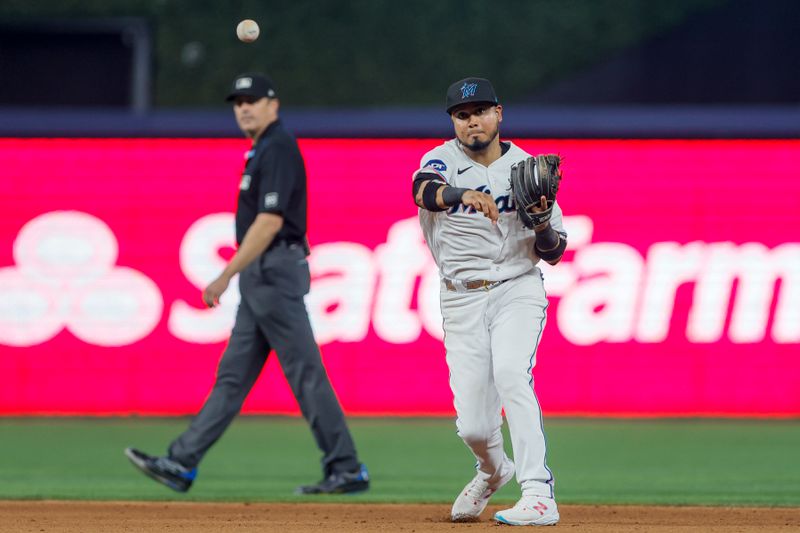 Jun 4, 2023; Miami, Florida, USA; Miami Marlins second baseman Luis Arraez (3) throws the baseball for an out against the Oakland Athletics shortstop Nick Allen during the eighth inning at loanDepot Park. Mandatory Credit: Sam Navarro-USA TODAY Sports