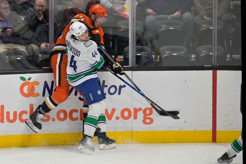 Nov 5, 2024; Anaheim, California, USA; Vancouver Canucks left wing Kiefer Sherwood (44) checks Anaheim Ducks left wing Ross Johnston (44) into the boards in the first period at Honda Center. Mandatory Credit: Jayne Kamin-Oncea-Imagn Images