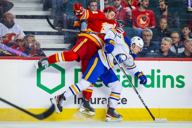 Mar 24, 2024; Calgary, Alberta, CAN; Buffalo Sabres right wing JJ Peterka (77) and Calgary Flames defenseman MacKenzie Weegar (52) battles for the puck during the first period at Scotiabank Saddledome. Mandatory Credit: Sergei Belski-USA TODAY Sports