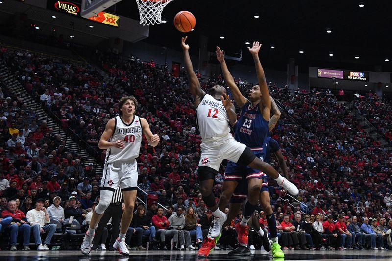 Jan 3, 2024; San Diego, California, USA; San Diego State guard Darrion Trammell (12) goes to the basket past Fresno State guard Leo Colimerio (23) during the first half at Viejas Arena. Mandatory Credit: Orlando Ramirez-USA TODAY Sports 