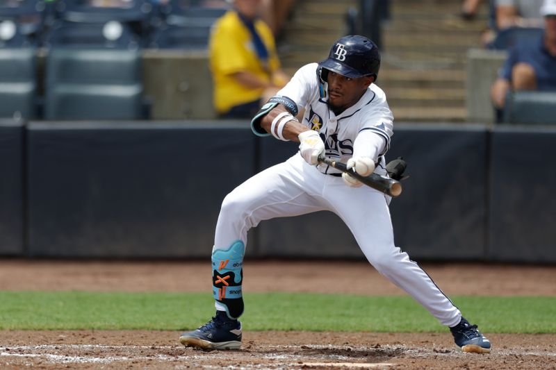 Jul 20, 2025; Tampa, Florida, USA; Tampa Bay Rays center fielder Chandler Simpson (14) bunts against the Baltimore Orioles in the fourth inning at George M. Steinbrenner Field. Mandatory Credit: Nathan Ray Seebeck-Imagn Images