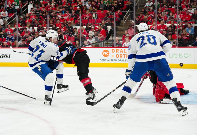 Oct 11, 2024; Raleigh, North Carolina, USA;  Tampa Bay Lightning center Brayden Point (21) scores a goal against the Carolina Hurricanes during the second period at PNC Arena. Mandatory Credit: James Guillory-Imagn Images