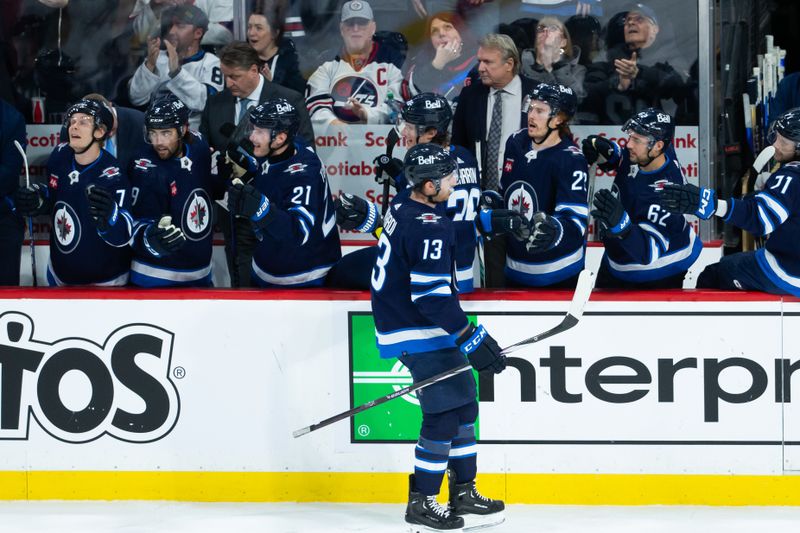 Jan 11, 2024; Winnipeg, Manitoba, CAN; Winnipeg Jets forward Gabriel Vilardi (13) is congratulated by his team mates on his goal against Chicago Blackhawks goalie Petr Mrazek (34) during the third period at Canada Life Centre. Mandatory Credit: Terrence Lee-USA TODAY Sports