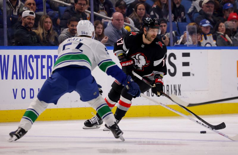 Nov 29, 2024; Buffalo, New York, USA;  Vancouver Canucks center Aatu Raty (54) defends as Buffalo Sabres left wing Jason Zucker (17) skates up ice with the puck during the second period at KeyBank Center. Mandatory Credit: Timothy T. Ludwig-Imagn Images