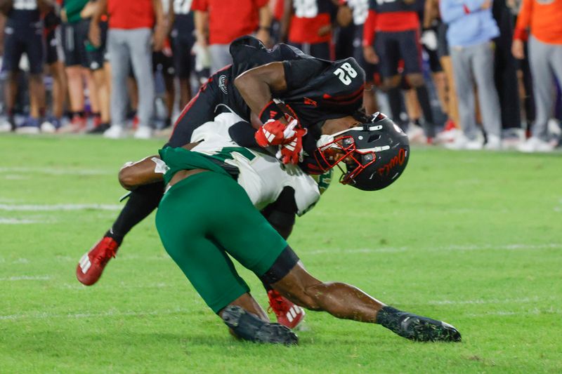 Nov 1, 2024; Boca Raton, Florida, USA;  Florida Atlantic Owls wide receiver Jabari Smith (82) is tackled by South Florida Bulls safety Caqavouis Berryhill (5) during the second quarter at FAU Stadium. Mandatory Credit: Reinhold Matay-Imagn Images