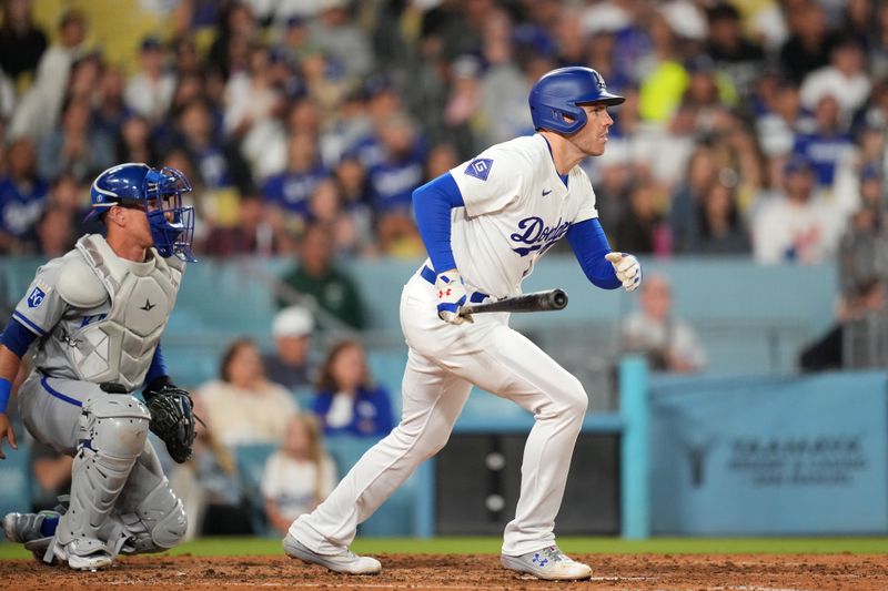 Jun 14, 2024; Los Angeles, California, USA; Los Angeles Dodgers first baseman Freddie Freeman (5) follows through on a run-scoring single in the eighth inning as Kansas City Royals catcher Salvador Perez (13) watches at Dodger Stadium. Mandatory Credit: Kirby Lee-USA TODAY Sports