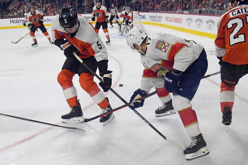 Dec 5, 2024; Philadelphia, Pennsylvania, USA; Philadelphia Flyers defenseman Egor Zamula (5) and Florida Panthers center Evan Rodrigues (17) battle for the puck during the second period at Wells Fargo Center. Mandatory Credit: Eric Hartline-Imagn Images