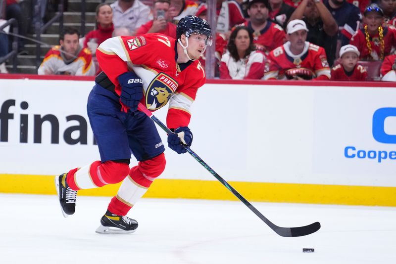 Apr 28, 2025; Sunrise, Florida, USA; Florida Panthers defenseman Niko Mikkola (77) controls the puck against the Tampa Bay Lightning during the first period in game four of the first round of the 2025 Stanley Cup Playoffs at Amerant Bank Arena. Mandatory Credit: Rich Storry-Imagn Images