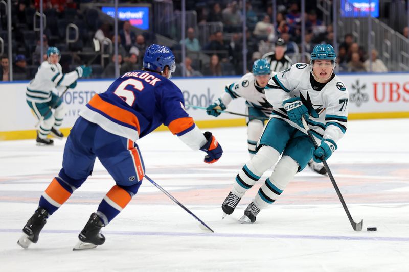 Oct 21, 2025; Elmont, New York, USA; San Jose Sharks center Macklin Celebrini (71) skates with the puck against New York Islanders defenseman Ryan Pulock (6) during the third period at UBS Arena. Mandatory Credit: Brad Penner-Imagn Images