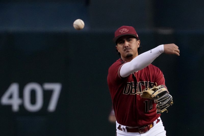 Mar 27, 2023; Phoenix, Arizona, USA; Arizona Diamondbacks second baseman Josh Rojas (10) throws to first base against the Cleveland Guardians during the first inning at Chase Field. Mandatory Credit: Joe Camporeale-USA TODAY Sports