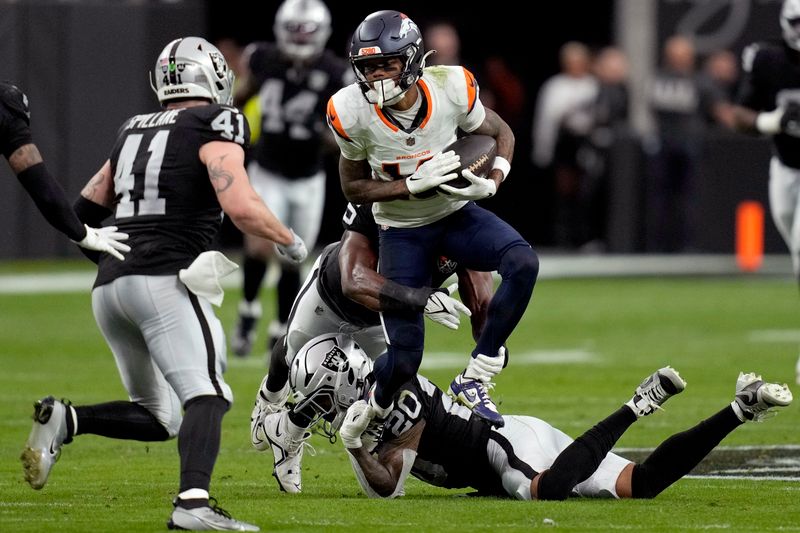 Denver Broncos wide receiver Troy Franklin is hit by Las Vegas Raiders safety Isaiah Pola-Mao (20) during the first half of an NFL football game, Sunday, Nov. 24, 2024, in Las Vegas. (AP Photo/John Locher)