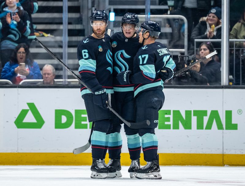 Nov 13, 2025; Seattle, Washington, USA; Seattle Kraken forward Kaapo Kakko (84), center, celebrates with defenseman Adam Larsson (6) andforward Jaden Schwartz (17) after scoring a goald during the first period against the Winnipeg Jets at Climate Pledge Arena. Mandatory Credit: Stephen Brashear-Imagn Images