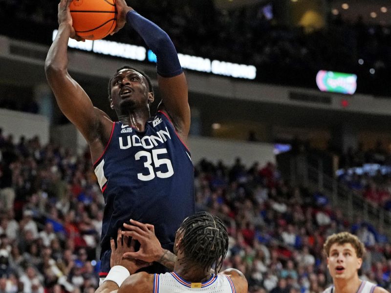 Mar 23, 2025; Raleigh, NC, USA; Connecticut Huskies center Samson Johnson (35) dunks the ball during the first half as Florida Gators guard Alijah Martin (15) defends in the second round of the NCAA Tournament at Lenovo Center. Mandatory Credit: Bob Donnan-Imagn Images