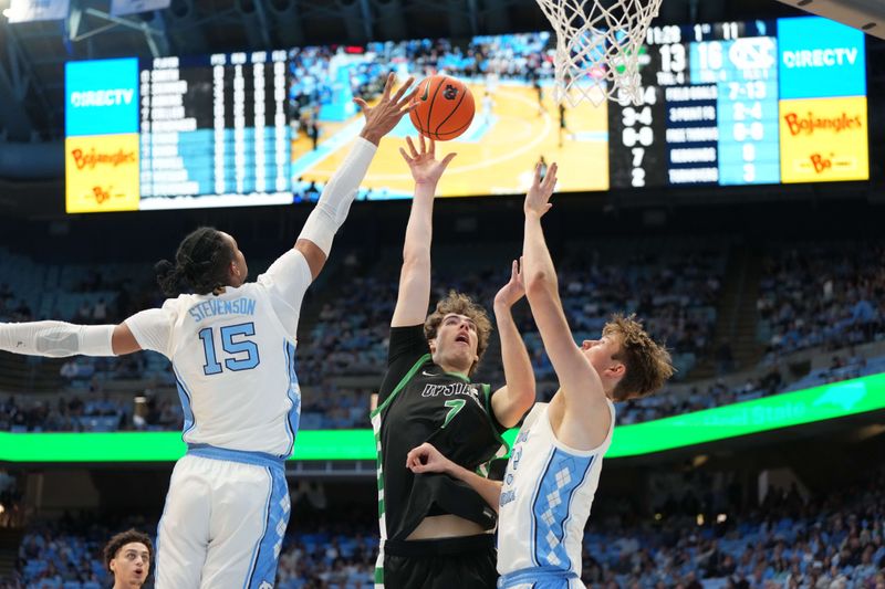 Dec 13, 2025; Chapel Hill, North Carolina, USA; USC Upstate Spartans center Coen Collier (7) shoots as North Carolina Tar Heels forward Jarin Stevenson (15) and center Henri Veesaar (13) defend in the first half at Dean E. Smith Center. Mandatory Credit: Bob Donnan-Imagn Images