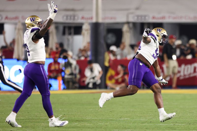 Nov 4, 2023; Los Angeles, California, USA; Washington Huskies defensive lineman Jayvon Parker (94) celebrates with defensive end Zion Tupuola-Fetui (4) after the Washington Huskies defeat the USC Trojans at United Airlines Field at Los Angeles Memorial Coliseum. Mandatory Credit: Jessica Alcheh-USA TODAY Sports