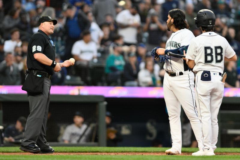 Jun 14, 2023; Seattle, Washington, USA; Seattle Mariners third baseman Eugenio Suarez (28) talks to umpire Sean Barber (29) after striking out against the Miami Marlins during the seventh inning at T-Mobile Park. Mandatory Credit: Steven Bisig-USA TODAY Sports