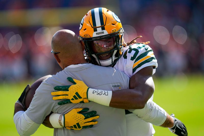 Green Bay Packers running back Aaron Jones (33) hugs a coach against the Denver Broncos during an NFL football game Sunday, Oct. 22, 2023, in Denver. (AP Photo/Jack Dempsey)