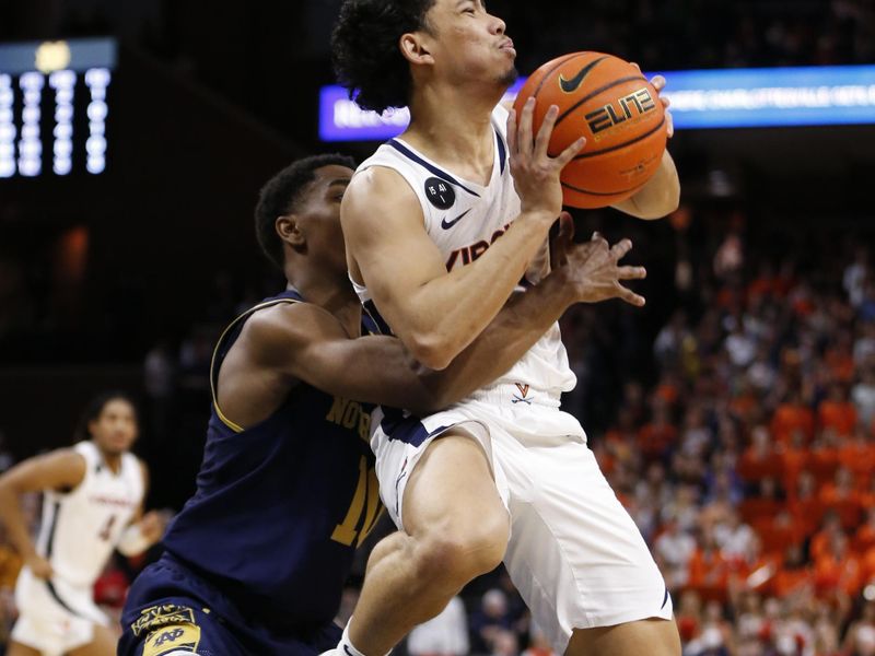 Feb 18, 2023; Charlottesville, Virginia, USA; Virginia Cavaliers guard Kihei Clark (0) controls the ball as Notre Dame Fighting Irish guard Marcus Hammond (10) defends during the second half at John Paul Jones Arena. Mandatory Credit: Amber Searls-USA TODAY Sports