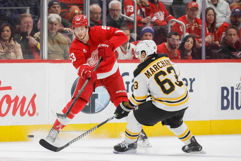 Nov 23, 2024; Detroit, Michigan, USA; Detroit Red Wings defenseman Moritz Seider (53) passes the puck under pressure from Boston Bruins left wing Brad Marchand (63) during the second period at Little Caesars Arena. Mandatory Credit: Brian Bradshaw Sevald-Imagn Images