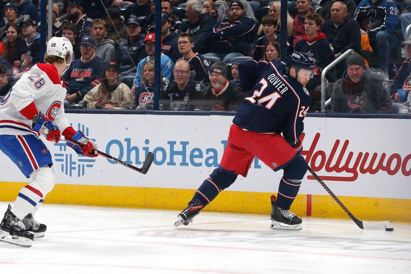 Nov 27, 2024; Columbus, Ohio, USA; Columbus Blue Jackets center Mathieu Olivier (24) picks up a loose puck as Montreal Canadiens center Christian Dvorak (28) trails the play during the first period at Nationwide Arena. Mandatory Credit: Russell LaBounty-Imagn Images