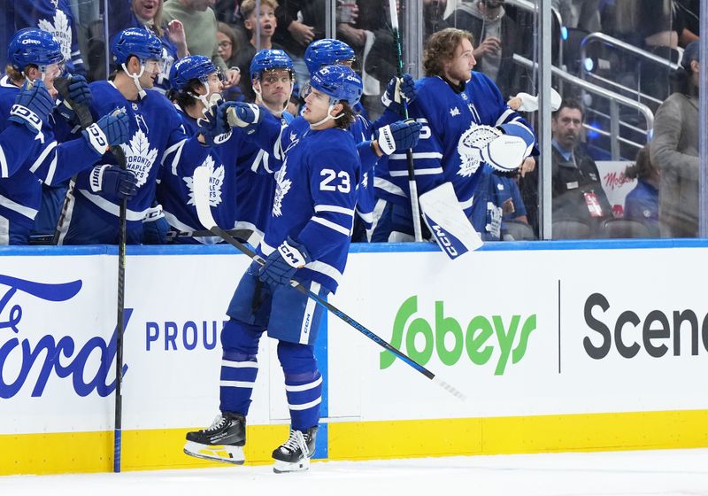 Oct 12, 2024; Toronto, Ontario, CAN; Toronto Maple Leafs left wing Matthew Knies (23) celebrates at the bench after scoring a goal against the Pittsburgh Penguins during the second period at Scotiabank Arena. Mandatory Credit: Nick Turchiaro-Imagn Images