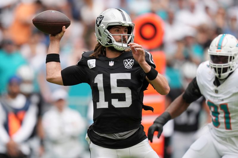 Las Vegas Raiders quarterback Gardner Minshew (15) aims a pass during the first half of an NFL football game against the Miami Dolphins, Sunday, Nov. 17, 2024, in Miami Gardens, Fla. (AP Photo/Rebecca Blackwell)