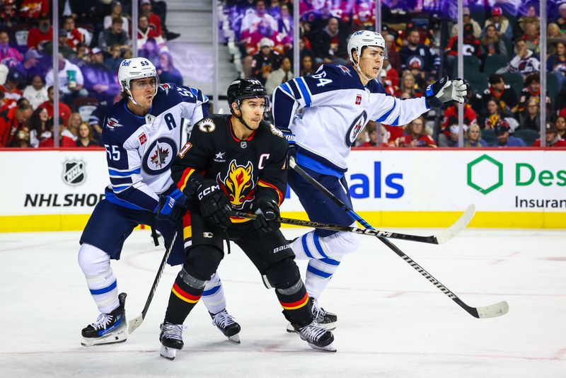 Oct 26, 2024; Calgary, Alberta, CAN; Calgary Flames center Mikael Backlund (11) and Winnipeg Jets center Mark Scheifele (55) fights for position during the second period at Scotiabank Saddledome. Mandatory Credit: Sergei Belski-Imagn Images