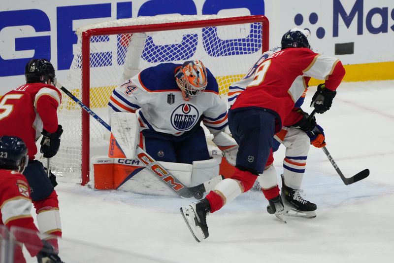 Jun 24, 2024; Sunrise, Florida, USA; Edmonton Oilers goaltender Skinner Stuart (74) and defenseman Philip Broberg (86) defend against Florida Panthers forward Sam Bennett (9) during the third period in game seven of the 2024 Stanley Cup Final at Amerant Bank Arena. Mandatory Credit: Jim Rassol-USA TODAY Sports