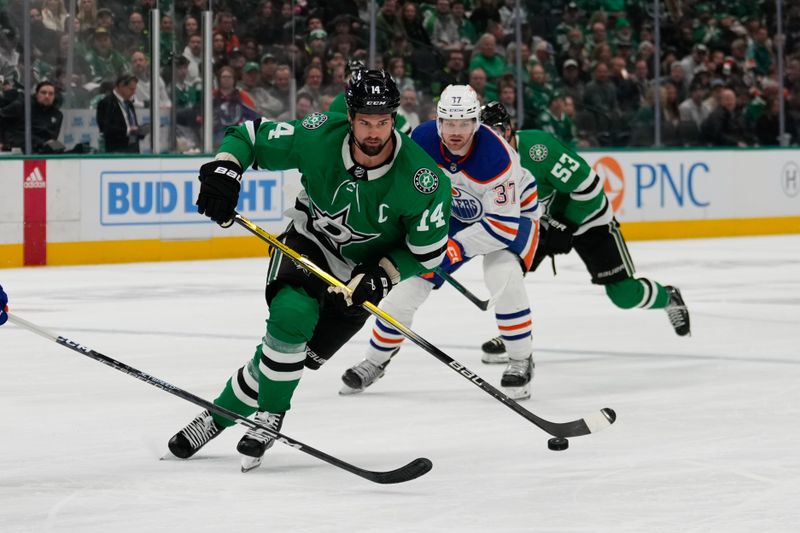 Feb 17, 2024; Dallas, Texas, USA; Dallas Stars left wing Jamie Benn (14) skates with the puck against Edmonton Oilers left wing Warren Foegele (37) during the second period at American Airlines Center. Mandatory Credit: Chris Jones-USA TODAY Sports