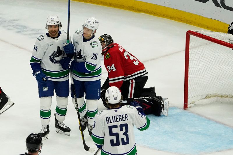 Oct 22, 2024; Chicago, Illinois, USA; Vancouver Canucks left wing Danton Heinen (20) scores a goal on Chicago Blackhawks goaltender Petr Mrazek (34) during the first period at United Center. Mandatory Credit: David Banks-Imagn Images