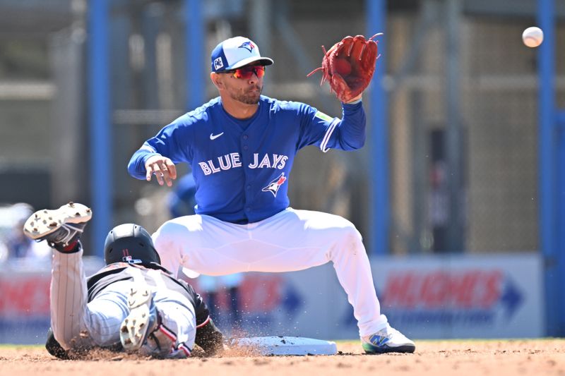 Mar 11, 2025; Dunedin, Florida, USA; Minnesota Twins designated hitter Mickey Gasper (11) dives back to second base as Toronto Blue Jays second baseman Andres Gimenez (0) waits for the ball in the second inning  at TD Ballpark. Mandatory Credit: Jonathan Dyer-Imagn Images