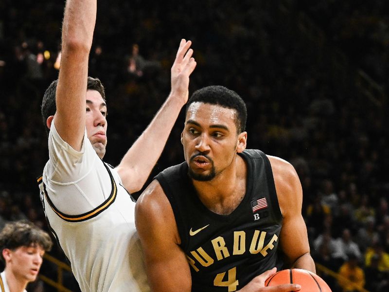 Feb 14, 2026; Iowa City, Iowa, USA; Purdue Boilermakers forward Trey Kaufman-Renn (4) controls the ball as Iowa Hawkeyes forward Alvaro Folgueiras (7) defends during the first half at Carver-Hawkeye Arena. Mandatory Credit: Jeffrey Becker-Imagn Images