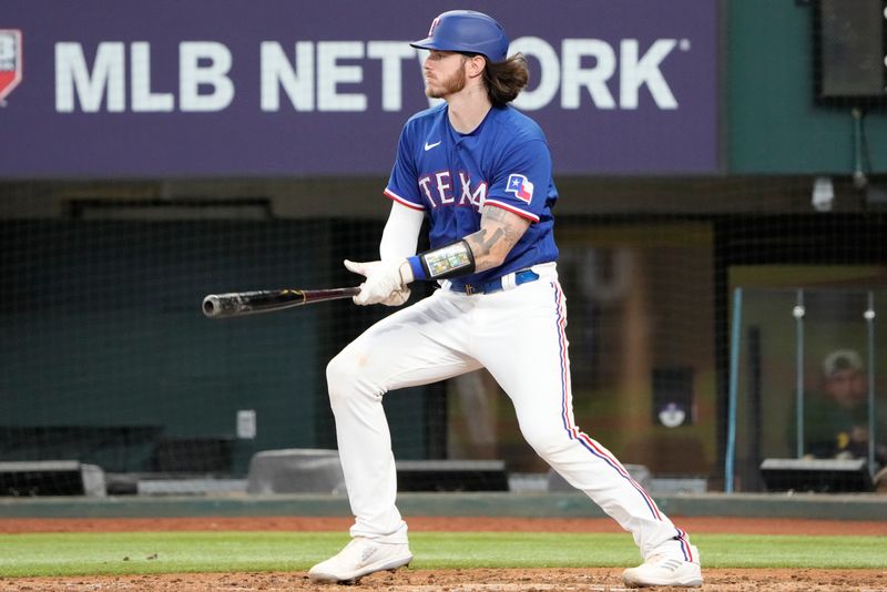 Mar 28, 2023; Arlington, Texas, USA; Texas Rangers catcher Jonah Heim (28) follows through on a single against the Kansas City Royals during the fifth inning of an exhibition game at Globe Life Field. Mandatory Credit: Jim Cowsert-USA TODAY Sports