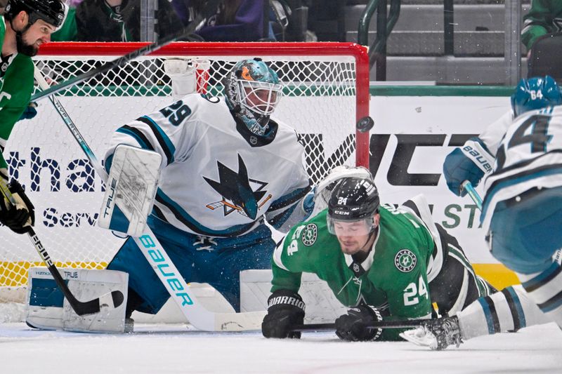 Nov 20, 2024; Dallas, Texas, USA; Dallas Stars center Roope Hintz (24) falls to the ice as San Jose Sharks goaltender Mackenzie Blackwood (29) stops a shot during the first period at the American Airlines Center. Mandatory Credit: Jerome Miron-Imagn Images