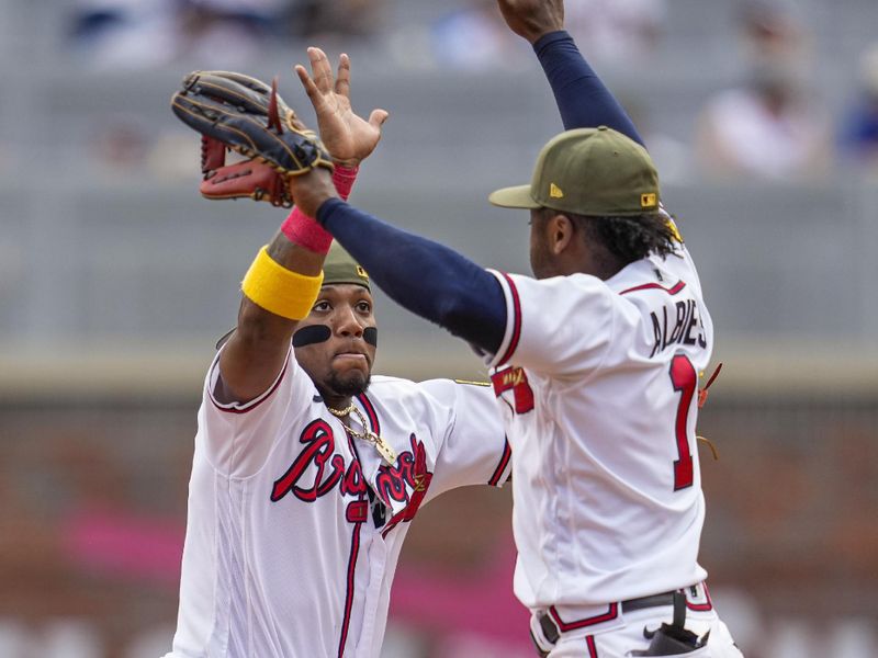 May 21, 2023; Cumberland, Georgia, USA; Atlanta Braves right fielder Ronald Acuna Jr. (13) and second baseman Ozzie Albies (1) react after the Braves defeated the Seattle Mariners at Truist Park. Mandatory Credit: Dale Zanine-USA TODAY Sports
